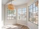 Bright dining area featuring three large windows with wood floors and modern pendant lighting at 6718 E Northridge St, Mesa, AZ 85215