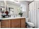 Bathroom featuring a white vanity, a large mirror, decorative orchids, and a shower with a white curtain at 6812 S 45Th Ave, Laveen, AZ 85339