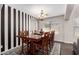 Elegant dining room with modern decor, hardwood floors, and a striped accent wall at 6812 S 45Th Ave, Laveen, AZ 85339