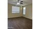 Cozy bedroom with a ceiling fan, wood-look flooring, and bright, natural light from windows at 6819 S 38Th Dr, Phoenix, AZ 85041