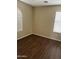 Well-lit bedroom with wood-look floors, neutral walls, and large windows with white blinds at 6819 S 38Th Dr, Phoenix, AZ 85041