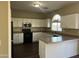 Well-lit kitchen featuring modern black appliances, ample white cabinetry and a breakfast bar at 6819 S 38Th Dr, Phoenix, AZ 85041