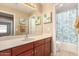 Well-lit bathroom featuring a sink, vanity, large mirror and a tub/shower combo with a stylish shower curtain at 700 W Gascon Rd, San Tan Valley, AZ 85143