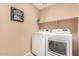 Clean laundry room equipped with modern washer and dryer, shelving, and a decorative laundry themed sign at 700 W Gascon Rd, San Tan Valley, AZ 85143