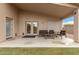 Covered patio with outdoor seating; a perfect spot for relaxing or entertaining guests, accessible through glass doors at 700 W Gascon Rd, San Tan Valley, AZ 85143