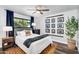 Cozy bedroom featuring a ceiling fan, wood-look floors, a gray upholstered bed frame, and natural light from a window at 718 E Tuckey Ln, Phoenix, AZ 85014