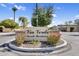 Via Verde Private Residence entrance sign surrounded by flowers, greenery, and a palm tree in the community at 718 E Tuckey Ln, Phoenix, AZ 85014