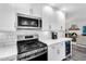 Close up of kitchen featuring stainless steel appliances, white cabinets, and modern lighting at 718 E Tuckey Ln, Phoenix, AZ 85014