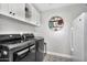 Well-equipped laundry room with modern appliances, overhead storage cabinets, and stylish patterned flooring at 718 E Tuckey Ln, Phoenix, AZ 85014