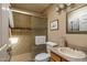 Bathroom featuring a tiled shower, toilet, and sink with a wooden cabinet at 8651 E Royal Palm Rd # 206, Scottsdale, AZ 85258