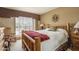 Cozy bedroom with a rustic wooden bed frame, a ceiling fan, and large windows with vertical blinds at 8651 E Royal Palm Rd # 206, Scottsdale, AZ 85258