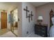 Neutral toned bedroom with dresser and mirrored closet reflecting into the nearby bathroom area at 8651 E Royal Palm Rd # 206, Scottsdale, AZ 85258