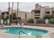 Community pool surrounded by lounge chairs and lush landscaping providing a relaxing outdoor space at 8651 E Royal Palm Rd # 206, Scottsdale, AZ 85258