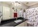 Bathroom with a festive Snoopy shower curtain, black countertop, and a framed mirror at 9212 W Salter Dr, Peoria, AZ 85382