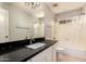 Bathroom featuring a large mirror, vanity with black countertop, and a shower/tub combo with a shower curtain at 9212 W Salter Dr, Peoria, AZ 85382