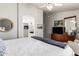 Bedroom with a ceiling fan, tv, a round mirror, and a doorway to an en suite bathroom at 9212 W Salter Dr, Peoria, AZ 85382