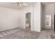 A spacious bedroom with neutral walls, gray carpet with entrance to bathroom with shower at 9212 W Salter Dr, Peoria, AZ 85382