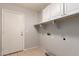 This laundry room has tile floors, cabinets above the washer/dryer, and a door to the outside at 9212 W Salter Dr, Peoria, AZ 85382