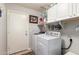 Well-organized laundry room featuring a side-by-side washer and dryer, white shelving, and ample storage at 9212 W Salter Dr, Peoria, AZ 85382