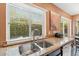 Functional kitchen featuring a stainless steel sink, granite countertops, and a view of the lush outdoor greenery at 9445 N 106Th St, Scottsdale, AZ 85258