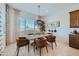 Stylish dining area with modern light fixture, a wooden table with seating for six, and bright natural light at 974 W Saddle Run, Apache Junction, AZ 85120