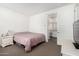 Simple bedroom featuring a queen bed with neutral carpet and a view into the bathroom at 9823 E Red Giant Dr, Mesa, AZ 85212