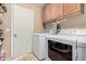This is a compact laundry room with a washer and dryer and overhead storage at 11023 E Florian Ave, Mesa, AZ 85208
