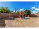 Backyard featuring a playground, landscaping, and a purple picnic table at 11813 W Sierra St, El Mirage, AZ 85335