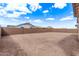 Large, empty backyard with a brick wall and clear blue skies above at 12378 W Marguerite Ave, Avondale, AZ 85323