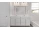 Bright bathroom featuring a double vanity with white countertops and cabinets at 12378 W Marguerite Ave, Avondale, AZ 85323