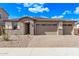 Stylish new home with a three-car garage, desert landscaping and an attractive front door at 12378 W Marguerite Ave, Avondale, AZ 85323