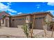 New home exterior features a three-car garage and desert landscaping under a blue sky at 12378 W Marguerite Ave, Avondale, AZ 85323