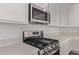 Gourmet kitchen features stainless steel appliances, quartz countertops, gas range, and white cabinetry at 12378 W Marguerite Ave, Avondale, AZ 85323