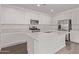 Bright kitchen features white cabinets, stainless steel appliances, quartz countertops, and wood-look tile flooring at 12378 W Marguerite Ave, Avondale, AZ 85323
