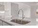 Up close, the kitchen sink is stainless steel and the countertop is quartz with full white cabinetry at 12378 W Marguerite Ave, Avondale, AZ 85323