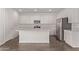 Well-lit kitchen boasts white cabinetry, quartz countertops, stainless appliances, and wood-look tile floors at 12378 W Marguerite Ave, Avondale, AZ 85323