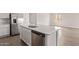 Modern kitchen featuring white cabinets, stainless steel appliances, and a large island with quartz countertop at 12378 W Marguerite Ave, Avondale, AZ 85323