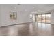 Bright, spacious living room with wood-look tile flooring and sliding glass doors at 12378 W Marguerite Ave, Avondale, AZ 85323