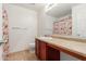 A bathroom with a tiled floor, flower curtain, cherry cabinet, toilet and mirror at 1265 S Aaron -- # 355, Mesa, AZ 85209