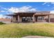 Large backyard with an outdoor dining area on a brick patio and a well-maintained lawn at 1312 N Joplin Cir, Mesa, AZ 85207