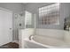 Bathroom featuring a soaking tub, shower, and privacy window that provide natural light at 1312 N Joplin Cir, Mesa, AZ 85207