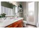 Well-lit bathroom with cherry vanity, white counter, frosted glass door, modern fixtures, and shelving at 1312 N Joplin Cir, Mesa, AZ 85207