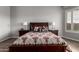 Well-lit bedroom with wood floors, a dark wood bed frame, and large windows for natural light at 1312 N Joplin Cir, Mesa, AZ 85207