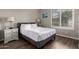 Cozy bedroom features a comfortable bed with white linens, wood flooring, and natural light from window with shutters at 1312 N Joplin Cir, Mesa, AZ 85207