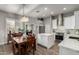 Bright kitchen featuring an island, stainless steel appliances, modern white cabinets, and a dining area at 1312 N Joplin Cir, Mesa, AZ 85207