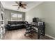 Inviting office with wood floors, a comfortable black sofa, a ceiling fan, and an organized workspace at 1312 N Joplin Cir, Mesa, AZ 85207