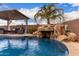 Gorgeous in-ground swimming pool with rock waterfall feature and covered patio area at 1312 N Joplin Cir, Mesa, AZ 85207