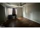 Comfortable bedroom featuring hardwood flooring, a ceiling fan, and a window for natural light at 15023 W Caribbean Ln, Surprise, AZ 85379