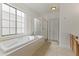 Bathroom with a large soaking tub, shower, window, tile floors, and vanity at 15469 W Dreyfus St, Surprise, AZ 85379