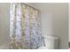 Bathroom featuring a toilet and a shower with a decorative blue and white shower curtain at 15469 W Dreyfus St, Surprise, AZ 85379